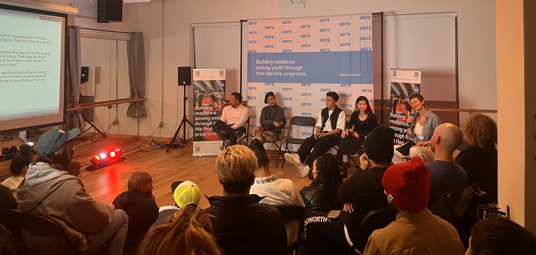 Dr. Japji Anna Bas leading a panel at Unity Charity in Toronto, with the audience gathered close